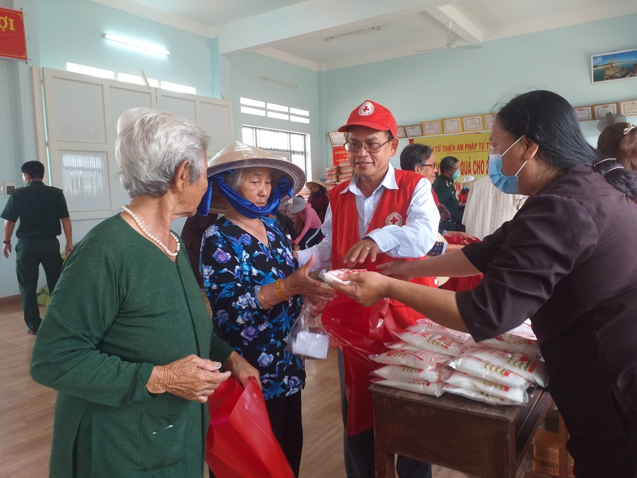 Ông Hà Văn Cát - Chủ tịch Hội CTĐ tỉnh trao quả và trò chuyện cùng bà cho xã đảo Nhơn Châu tại phiên chợ Nhân đạo 0 đồng do Hội CTĐ tỉnh tổ chức