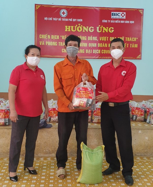 Ông Đặng Hữu Trung (thứ nhất, bên phải sang) trao hỗ trợ cho người dân khó khăn phường Trần Hưng Đạo