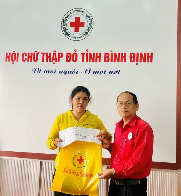 ​   Ông Hà Văn Cát - Chủ tịch Hội CTĐ tỉnh trao tiền và sữa cho mẹ em Long