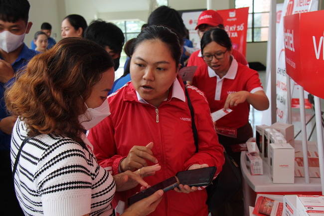 Nhân viên Viettel Bình Định hướng dẫn ĐVTN, giáo viên TX An Nhơn cách gắn mã QR thanh toán không dùng tiền mặt t`ại lễ phát động hưởng ứng Ngày Chuyển đổi số quốc gia. Ảnh: TRỌNG LỢI