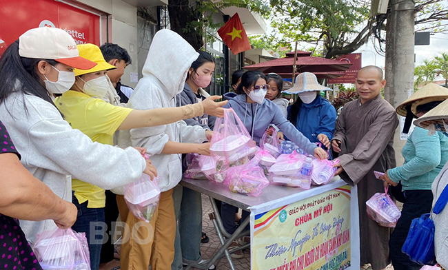 Đại đức Thích Nhuận Huy và người tình nguyện phát cơm chay miễn phí cho người dân thị trấn Phù Mỹ.