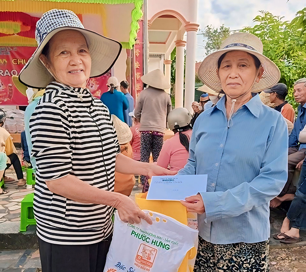 Bà Nguyễn Thị Thanh Vân (trái) trao quà cho người dân có hoàn cảnh khó khăn.