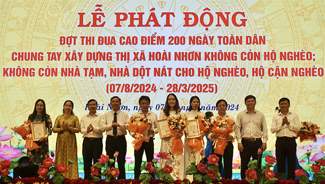 Lãnh đạo TX Hoài Nhơn tặng hoa và bảng vinh danh các DN ủng hộ kinh phí cho Quỹ “Vì người nghèo” của thị xã. Ảnh: T.K