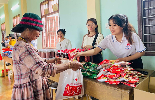 Trương Thị Mỹ Sen (bìa phải) tặng quà cho người dân tại chương trình Xuân nhân ái - Tết sẻ chia năm 2024. Ảnh: CLB 25